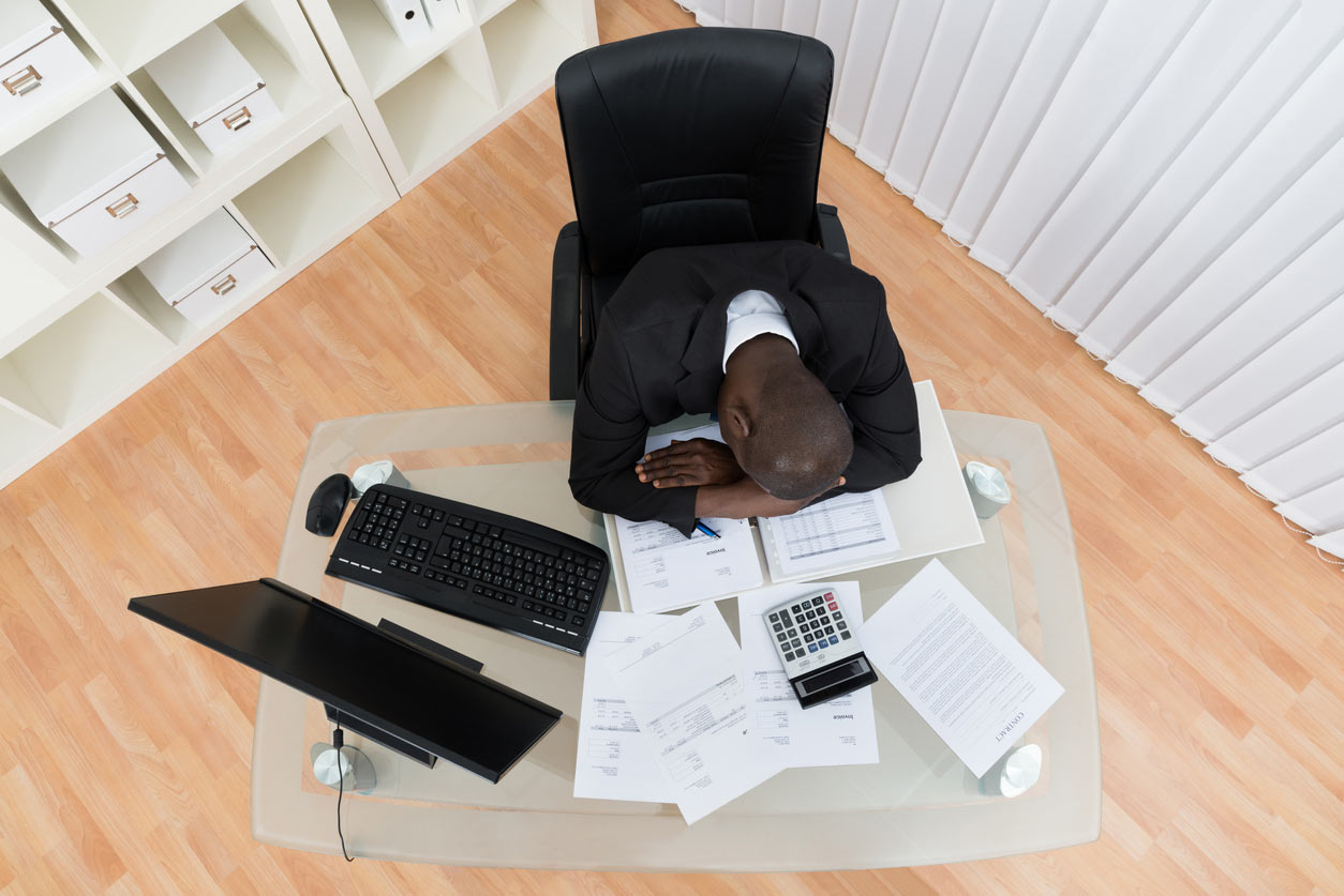 High Angle View Of Stressed Businessman Sleeping At Desk
